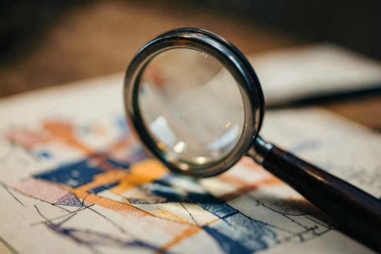 Uma lupa examinando um documento com gráficos e números, simbolizando a análise de direitos previdenciários.
