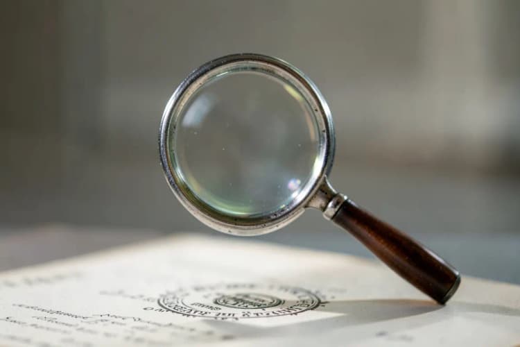 Uma lupa examinando um documento com selo oficial